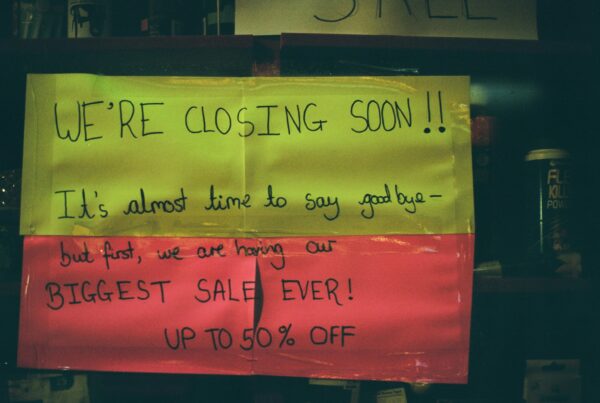 Sign on small business door that reads we're closing soon.