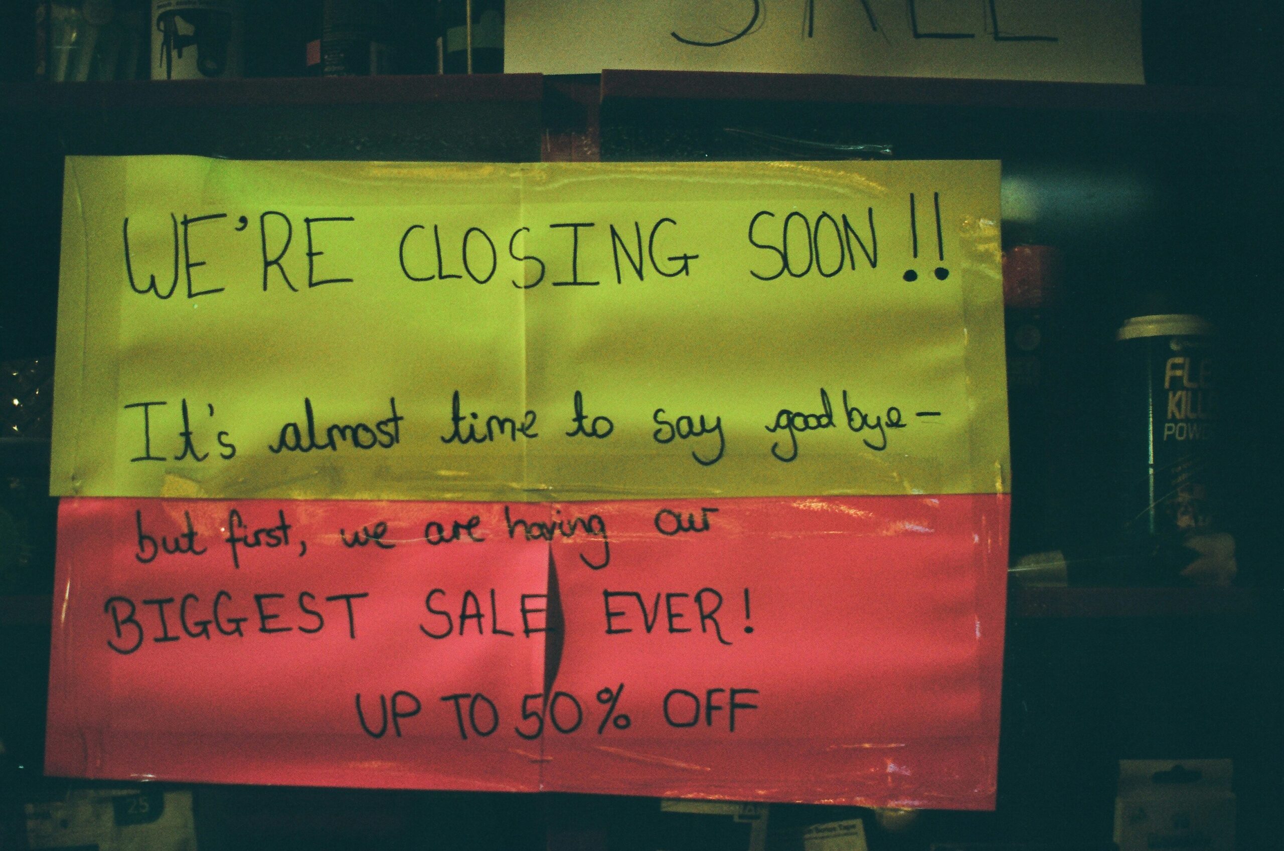 Sign on small business door that reads we're closing soon.